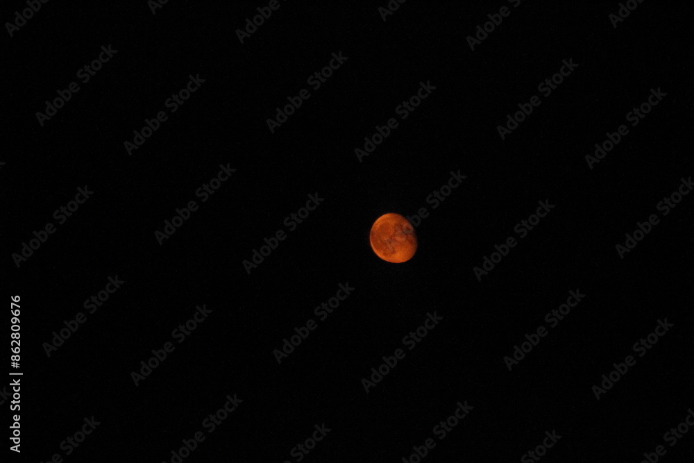 View of the red moon from the window of a moving train View of the red moon from the window of a moving train