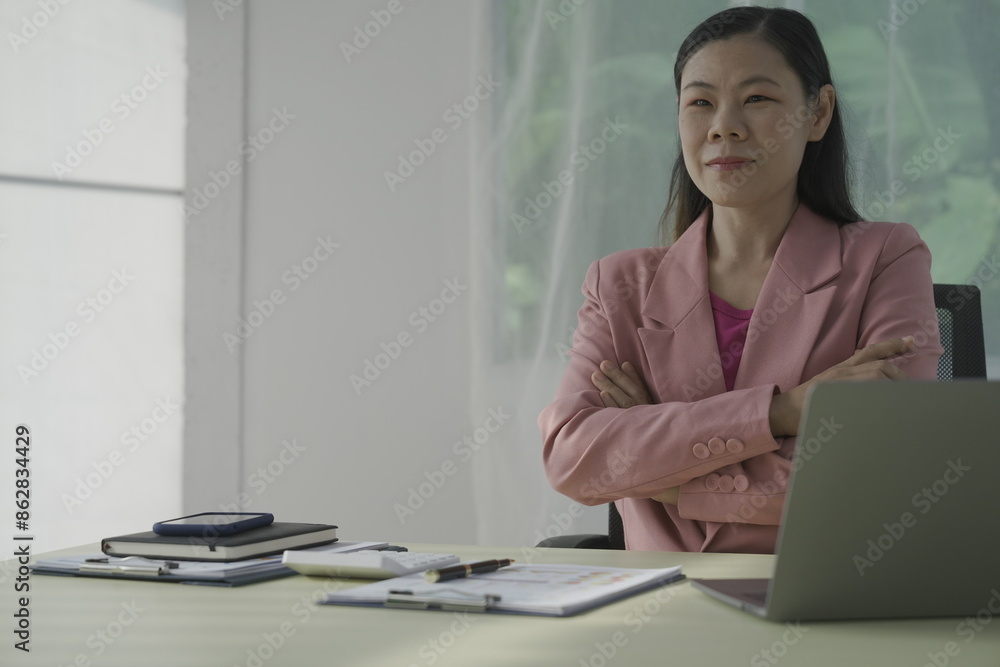 Happy young businesswoman in bright colored shirt uses computer and laptop in modern office Smiling manager while working on finance and marketing project Drink tea or coffee from a glass Happy young businesswoman in bright colored shirt uses computer and laptop in modern office Smiling manager while working on finance and marketing project Drink tea or coffee from a glass