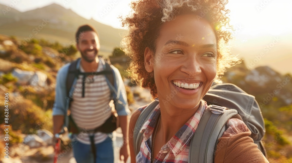 Smiling Black woman and man enjoy sunny mountain hiking with backpacks Smiling Black woman and man enjoy sunny mountain hiking with backpacks