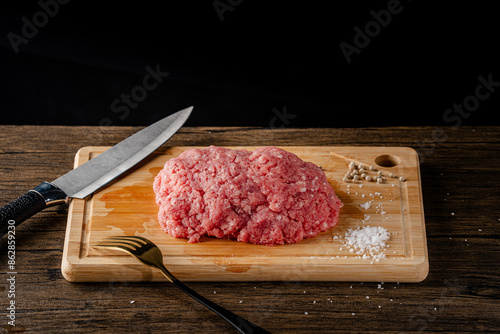 A slice of beef on a cutting board with a knife and fork