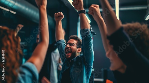 Team celebrating success with fists raised in an office setting.