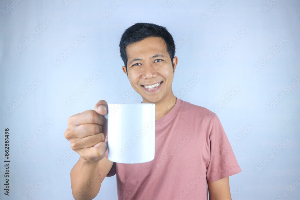 Smiling expression young asian man wearing t-shirt holding coffee cup, isolated on white background Smiling expression young asian man wearing t-shirt holding coffee cup, isolated on white background