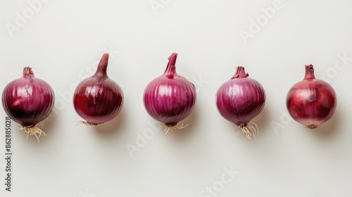 Tasty red onions arranged in a row on a white background photo