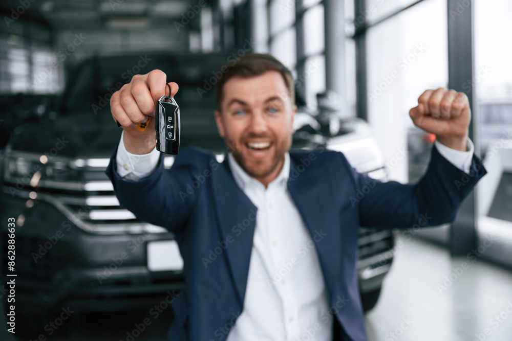 Fototapeta premium Happy new owner of automobile. A businessman is in a car dealership