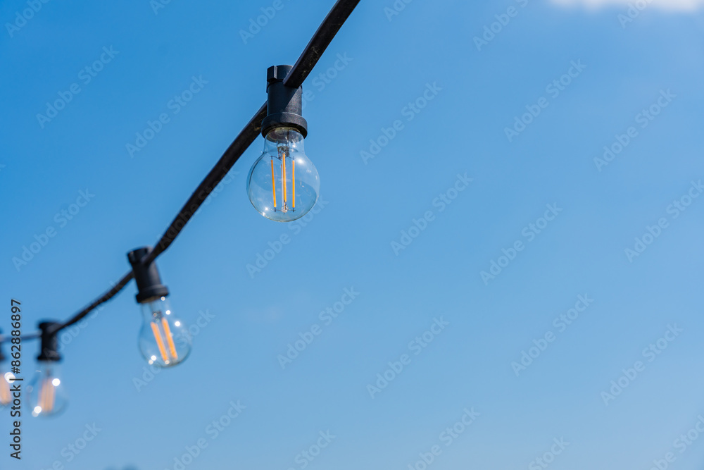 Light bulbs against a background of clear blue sky on a sunny day Light bulbs against a background of clear blue sky on a sunny day