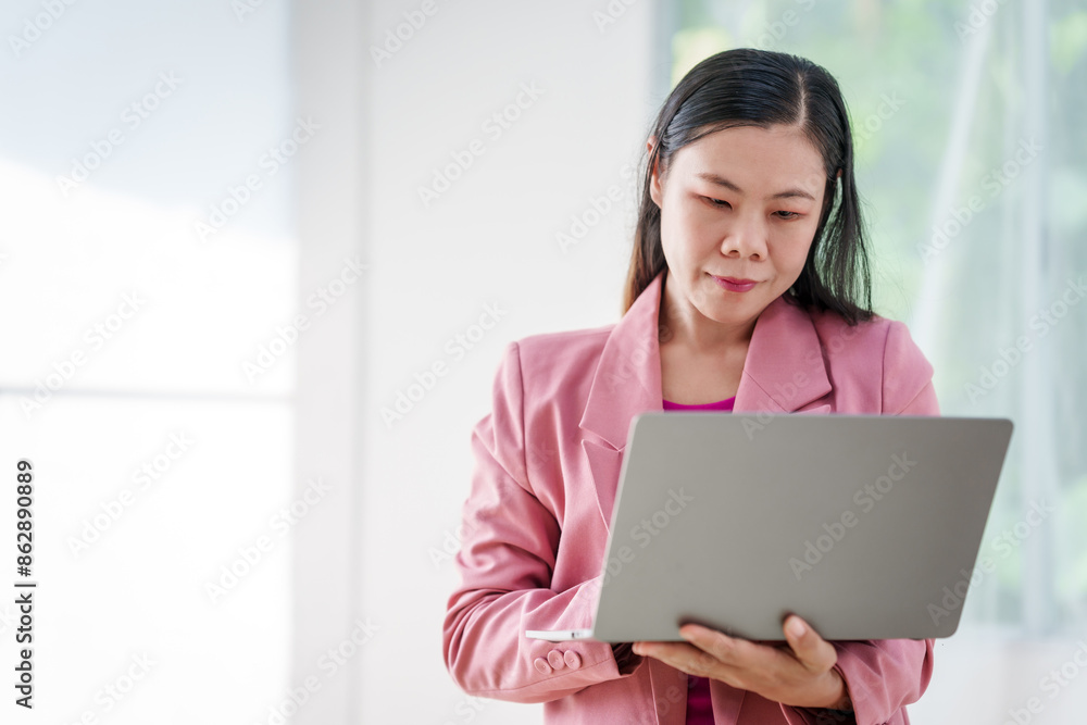 40-year-old middle-aged Asian businesswoman wearing pink suit, business finance, investment strategies, risk management. Skilled in planning, analysis, operations control for business success. 40-year-old middle-aged Asian businesswoman wearing pink suit, business finance, investment strategies, risk management. Skilled in planning, analysis, operations control for business success.