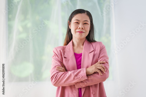 40-year-old middle-aged Asian businesswoman wearing pink suit, business finance, investment strategies, risk management. Skilled in planning, analysis, operations control for business success.