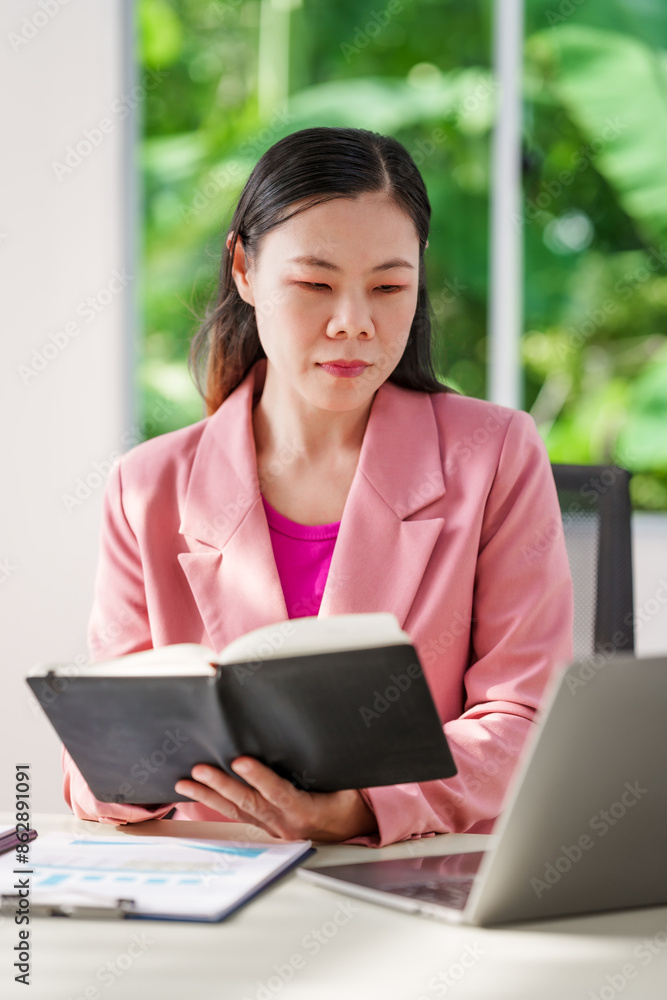 40-year-old middle-aged Asian businesswoman wearing pink suit, business finance, investment strategies, risk management. Skilled in planning, analysis, operations control for business success. 40-year-old middle-aged Asian businesswoman wearing pink suit, business finance, investment strategies, risk management. Skilled in planning, analysis, operations control for business success.