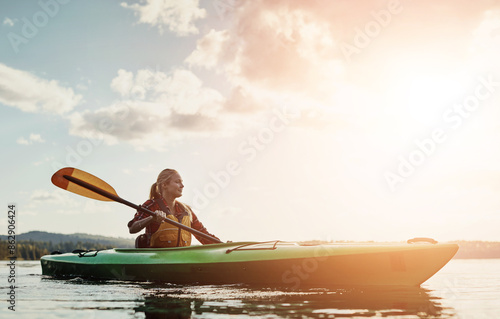 Lake, sky and woman rowing kayak outdoor for holiday, leisure or vacation in fresh air of nature. Adventure, clouds and travel with happy tourist person in river for break, journey or summer trip © peopleimages.com
