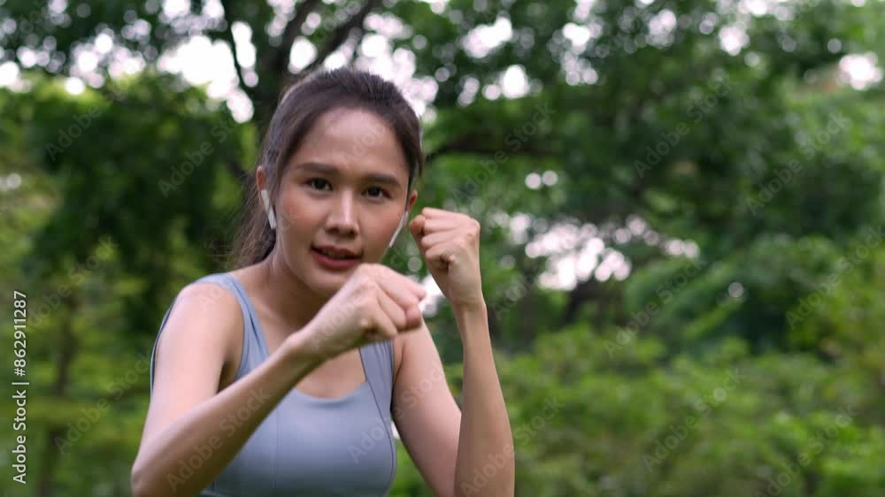 Fitness Asian Girl in tight sportswear doing exercises and punching boxing footwork cardio exercise in park. Female student boxer motivation. Fitness Asian Girl in tight sportswear doing exercises and punching boxing footwork cardio exercise in park. Female student boxer motivation.