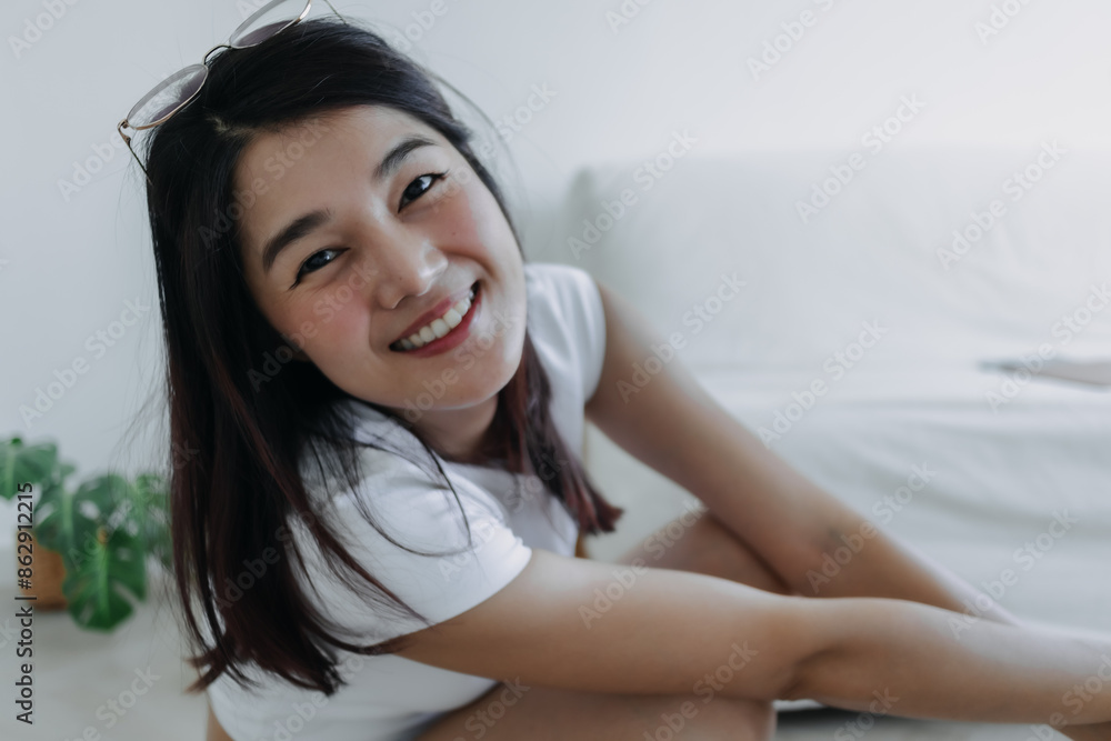 Close up of happy asian Thai woman sitting on floor in room, beautiful smiling to camera, happy single life concept. Close up of happy asian Thai woman sitting on floor in room, beautiful smiling to camera, happy single life concept.