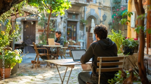 Digital Nomad in Europe - Working on Laptop at Quaint Outdoor CafÃ© in Historic European City © thesweetsheep