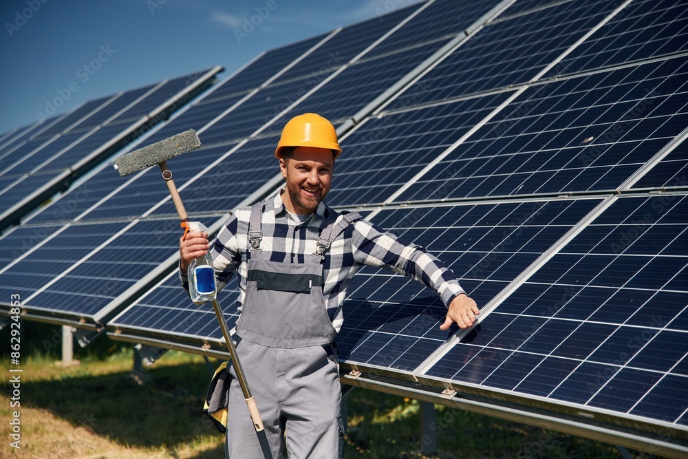 Procedure of cleaning the surface. Engineer with photovoltaic solar panels outdoors at daytime Procedure of cleaning the surface. Engineer with photovoltaic solar panels outdoors at daytime