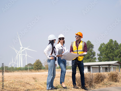 A group of engineers and architects are consulting. About taking care of wind turbines For a sustainable environment