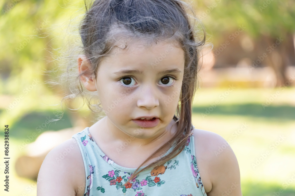 Confused and Naughty Face of Little Girl on a Hot Day in the Park Confused and Naughty Face of Little Girl on a Hot Day in the Park