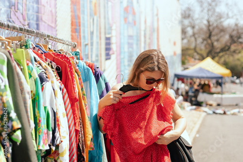 Obraz na plátně Portrait of a natural looking woman in 40s buying red dress on flea market