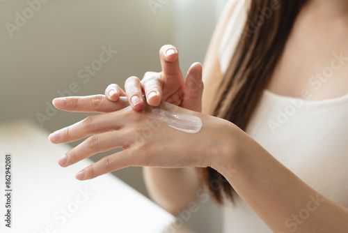 Foto Health skin care, beauty smile asian young woman, girl  hand applying, putting moisturizer on her arm, shoulder after shower bath at home