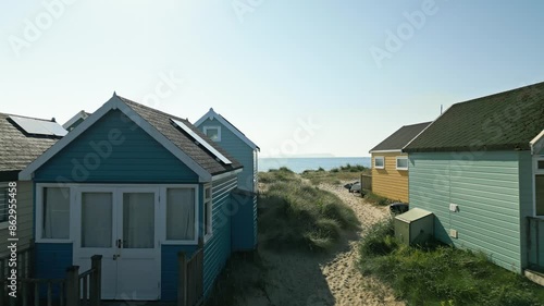 4k video of drone flying through beach huts towards beach and sea in Mudeford, Dorset