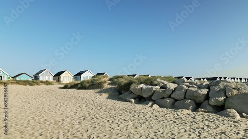 4k video of drone flying toward and over beach huts from sea in Mudeford, Dorset