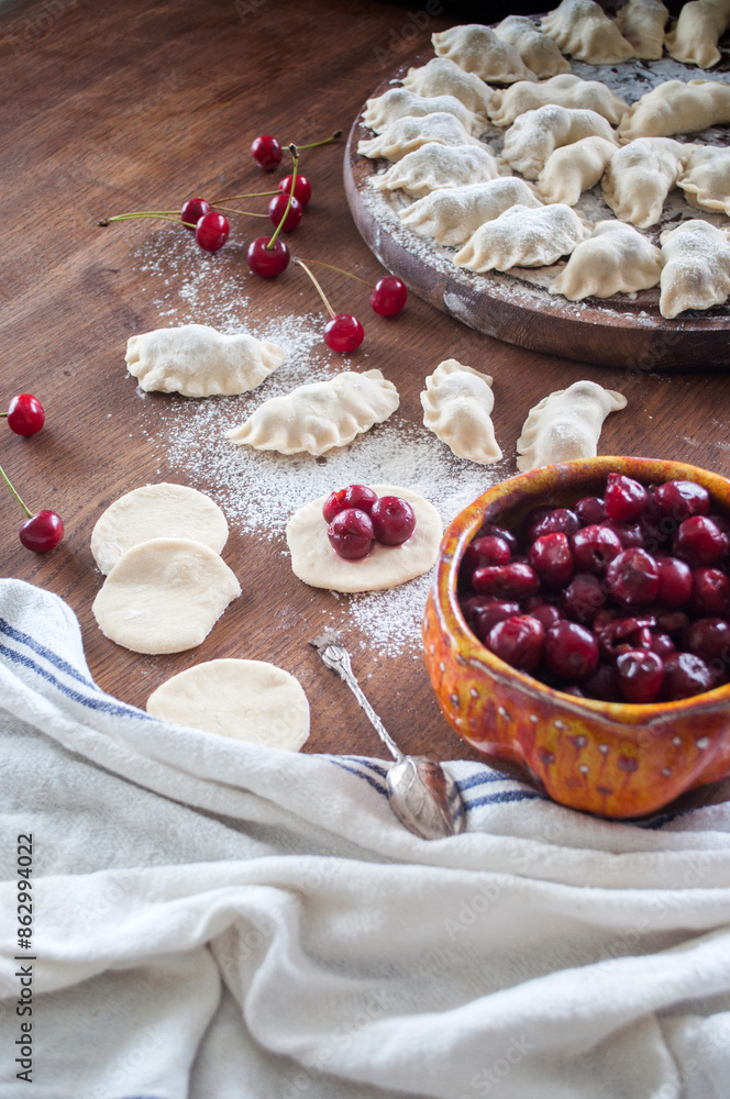 Fototapeta premium Cooking homemade varenyky (dumplings) with cherry. Ukrainian national quisine