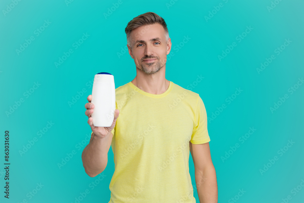 Haircare and skincare. Aftershave cosmetics product. Anti-dandruff hair gel. Offer aftershave. Presenting cosmetics product for men. Man hold aftershave. Man with unbranded product. Copy space Haircare and skincare. Aftershave cosmetics product. Anti-dandruff hair gel. Offer aftershave. Presenting cosmetics product for men. Man hold aftershave. Man with unbranded product. Copy space