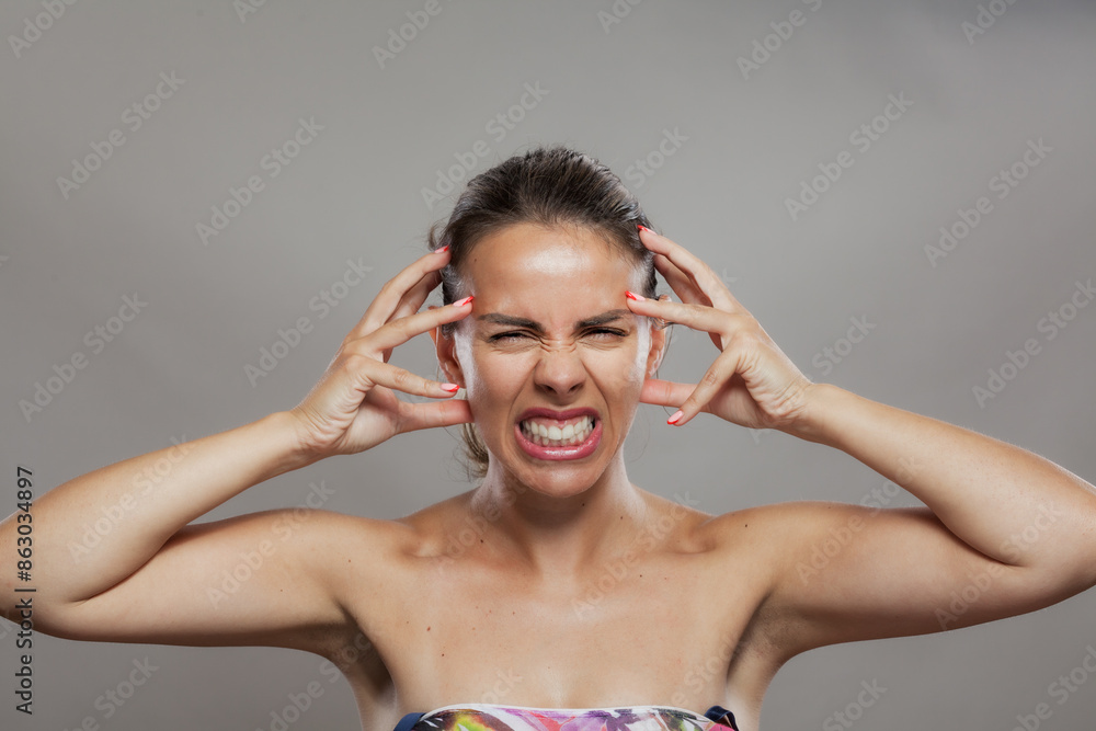 Frustrated young woman with hands on head making a face of annoyance Frustrated young woman with hands on head making a face of annoyance