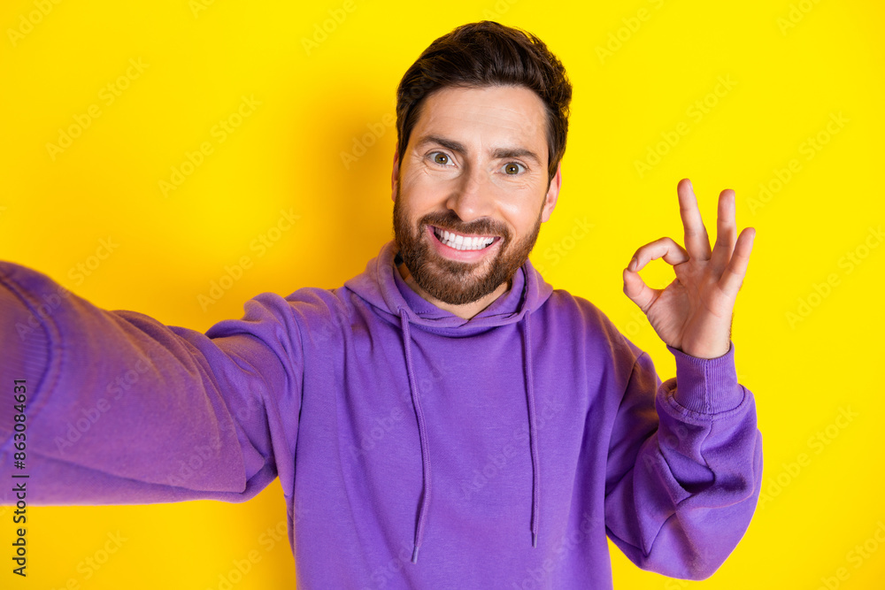 Photo portrait of attractive young man take selfie photo okey sign dressed stylish violet clothes isolated on yellow color background Photo portrait of attractive young man take selfie photo okey sign dressed stylish violet clothes isolated on yellow color background