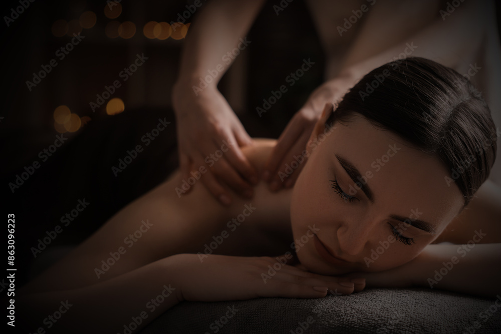 Beautiful young woman lying on table during massage in salon Beautiful young woman lying on table during massage in salon
