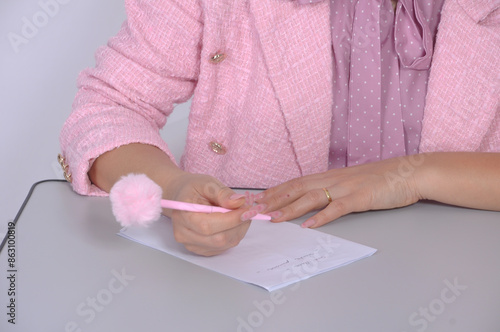 beldade jovem influenciadora segurando caneta rosa patricinha  photo