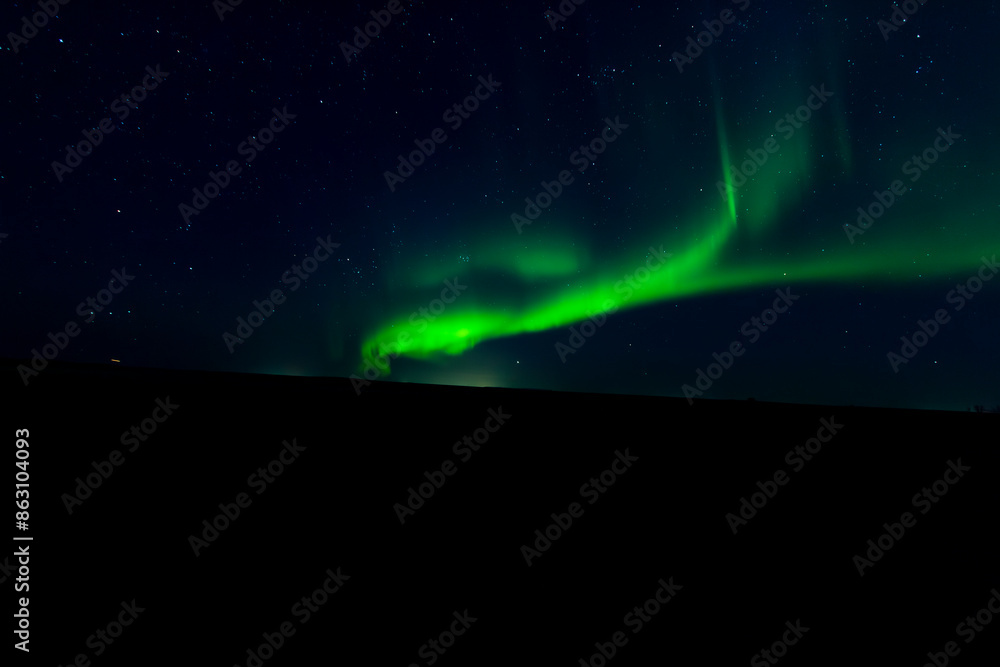 A mesmerizing view of the northern lights illuminating the night sky above a serene hill A mesmerizing view of the northern lights illuminating the night sky above a serene hill