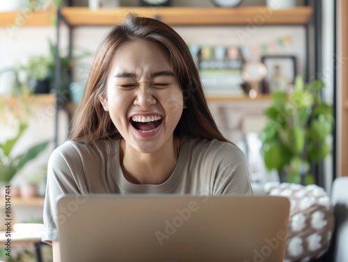 Happy young woman working remotely on virtual video team meeting call, remote work and flexible culture concept, smiling asian female digital nomad freelancing on laptop from home, copy space