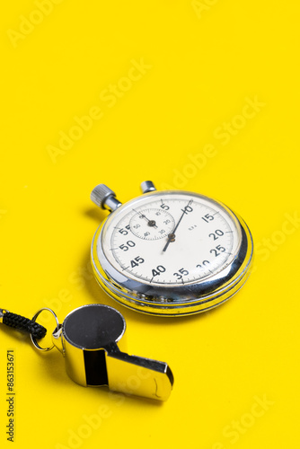 Whistle and stopwatch on a yellow background. Stopwatch. photo