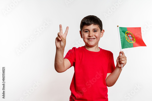 A young boy is holding a Portugal flag and making a peace sign