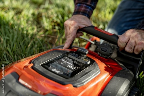 Homeowner Checking Battery Level on Cordless Lawn Mower Digital Display - Spring Garden Maintenance © spyrakot