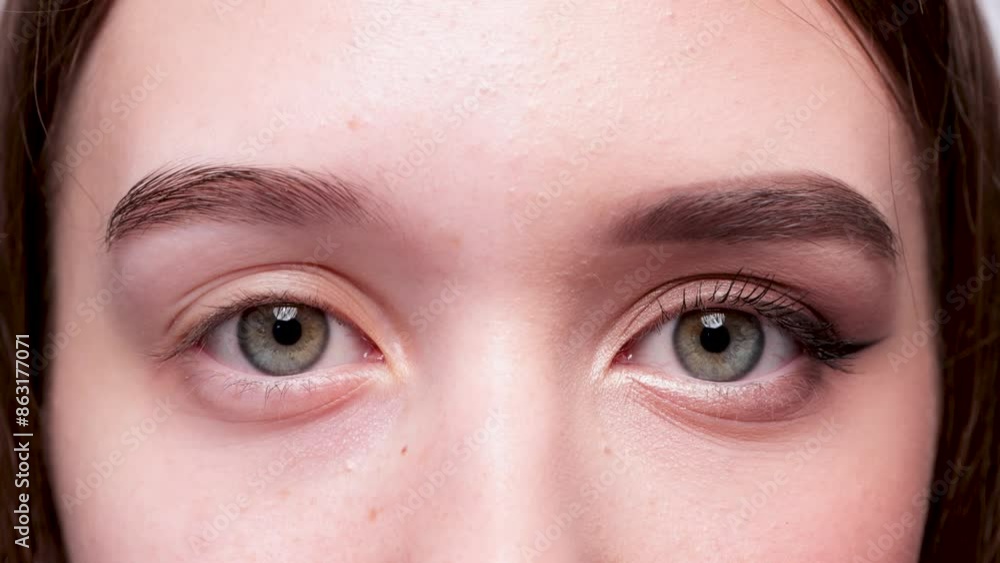 A young beautiful girl removes makeup with a cotton pad and micellar water from her face and eyes. A young beautiful girl removes makeup with a cotton pad and micellar water from her face and eyes.
