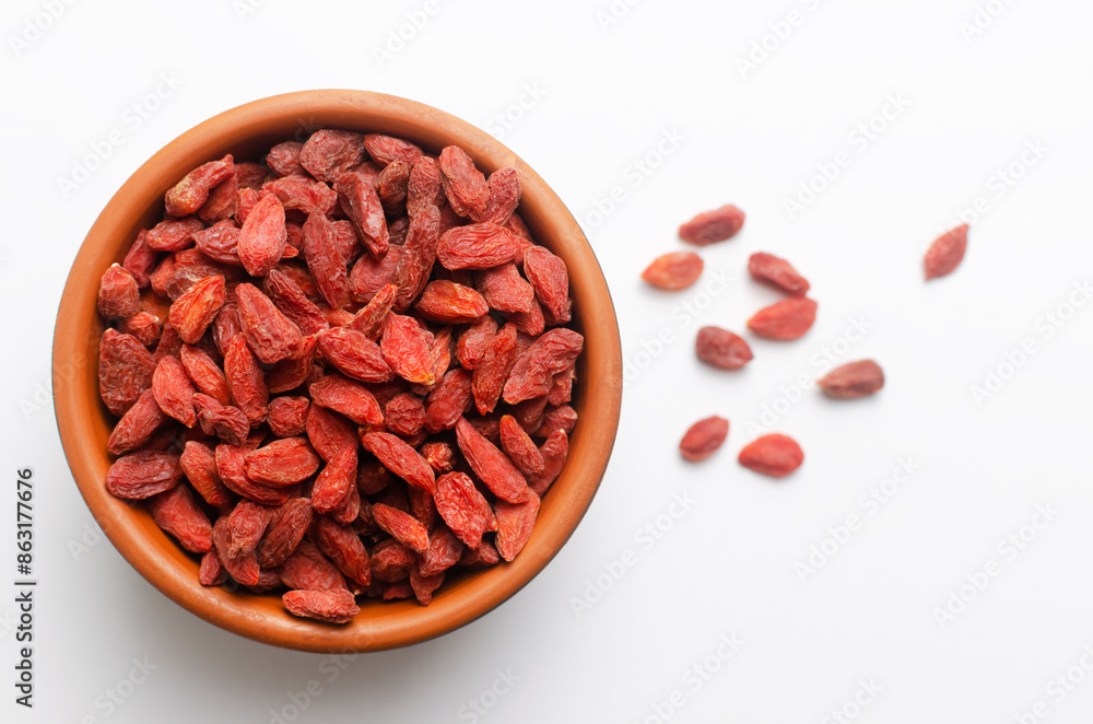 Goji berries in a brown ceramic bowl on a white background. Superfood. Vegetarian, vegan. Healthy food concept. Goji berries in a brown ceramic bowl on a white background. Superfood. Vegetarian, vegan. Healthy food concept.