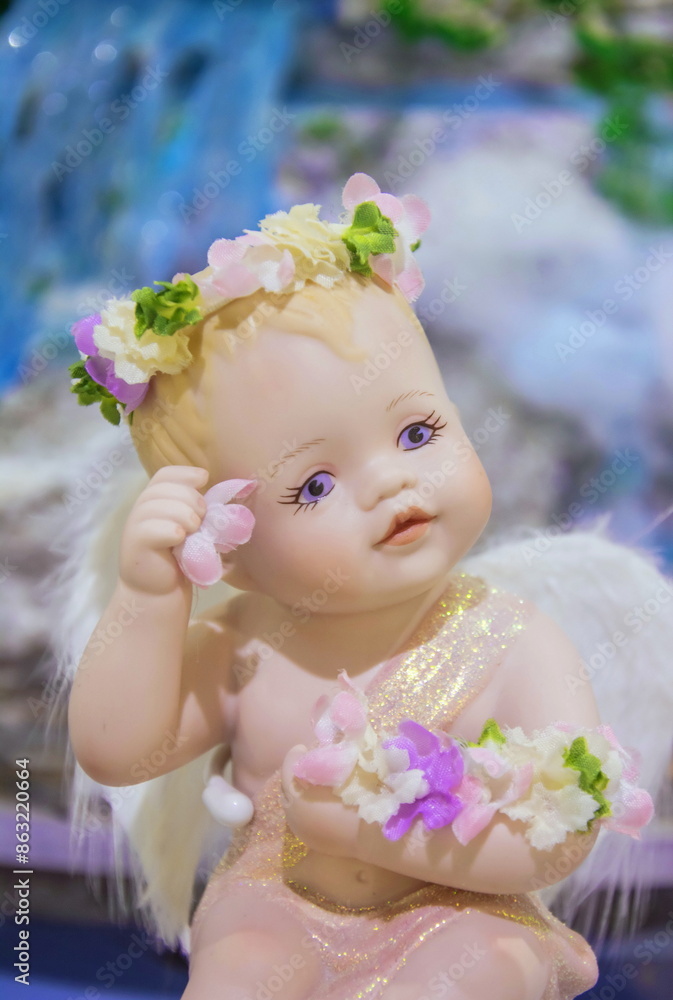 A cute souvenir in the form of a chubby angel (cupid) with a flowers in his hands A cute souvenir in the form of a chubby angel (cupid) with a flowers in his hands