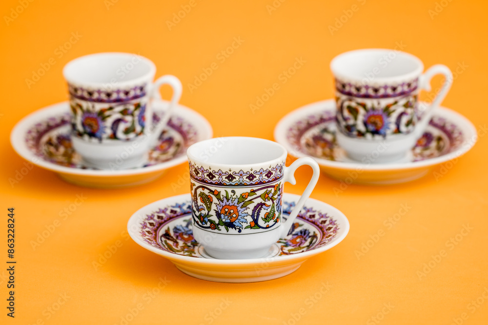 Classic porcelain Turkish coffee cups with floral design on orange background. Classic porcelain Turkish coffee cups with floral design on orange background.