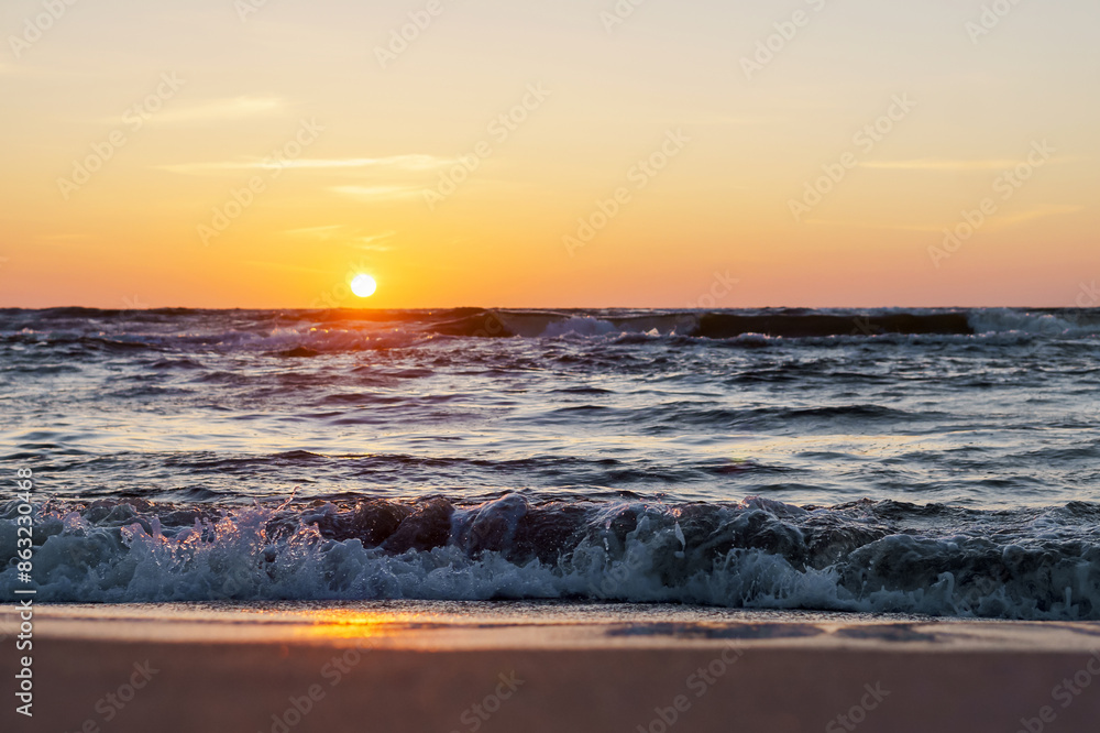 Obraz premium Sunset over the sea. Reflection of sunlight in the sea waves. The sky in the sunset rays. Baltic Sea.