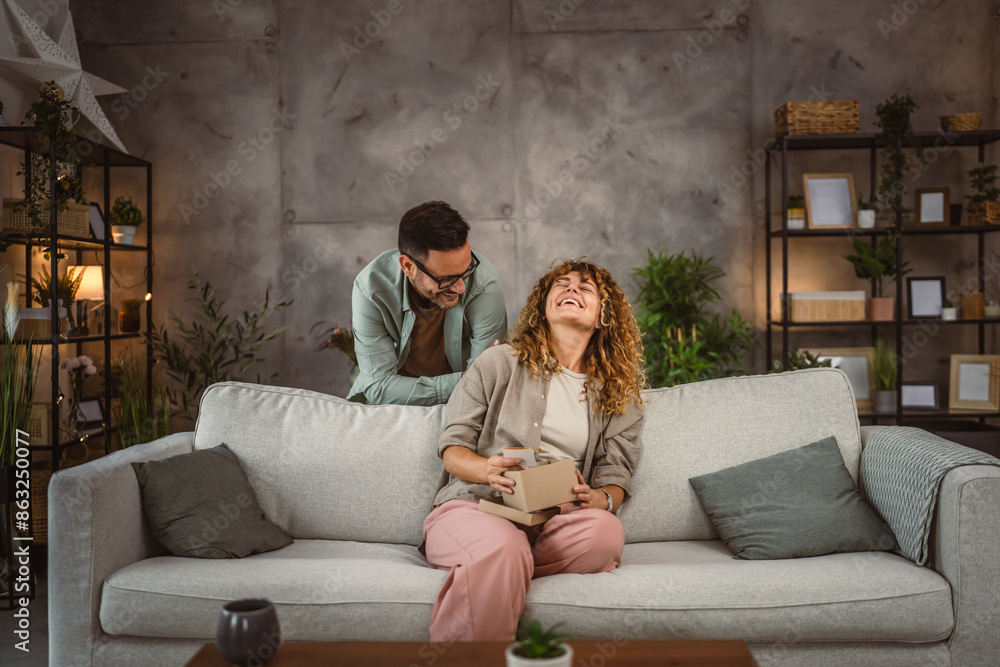 Surprised girlfriend hold gift read greeting card from her boyfriend Surprised girlfriend hold gift read greeting card from her boyfriend