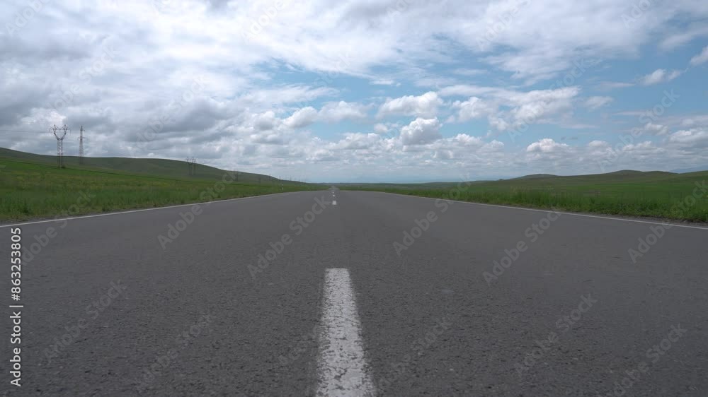 Asphalt road surrounded by green fields, travel concept Asphalt road surrounded by green fields, travel concept