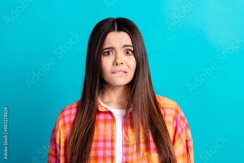 Portrait of nice girl bite lips stare wear checkered shirt isolated on turquoise color background © deagreez