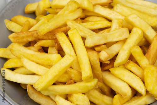 vue d'un plat de frites, en gros plan, sur une table