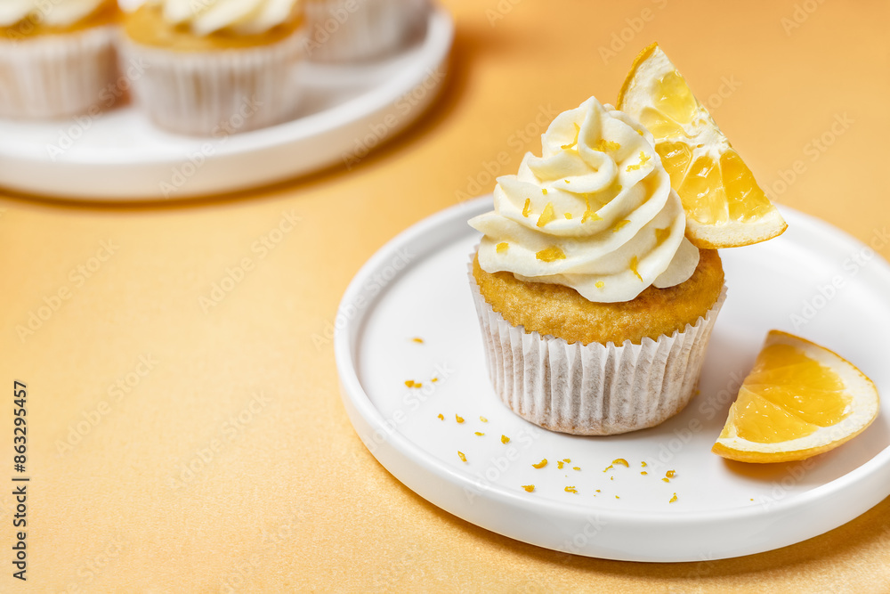Citrus flavored orange cupcakes with whipped frosting and fresh fruit slices close up Citrus flavored orange cupcakes with whipped frosting and fresh fruit slices close up