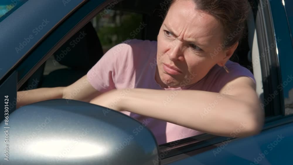 Female driver suffer from traffic jam. A view of depressed female sitting behind the car wheel and suffer from traffic jam in the street. Female driver suffer from traffic jam. A view of depressed female sitting behind the car wheel and suffer from traffic jam in the street.