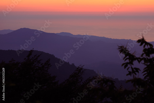 Landscape horizon line in the mountains, orange sunset and blue mountains.