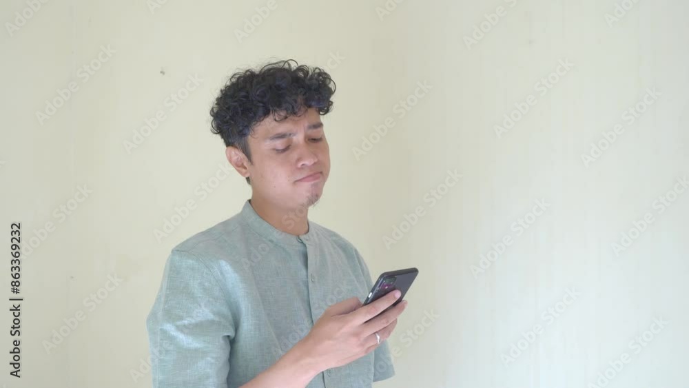 Moslem Asian man click smartphone and texting gesture when Ramadan celebration. The footage is suitable to use for business Ramadhan poster and Muslim content media. Moslem Asian man click smartphone and texting gesture when Ramadan celebration. The footage is suitable to use for business Ramadhan poster and Muslim content media.