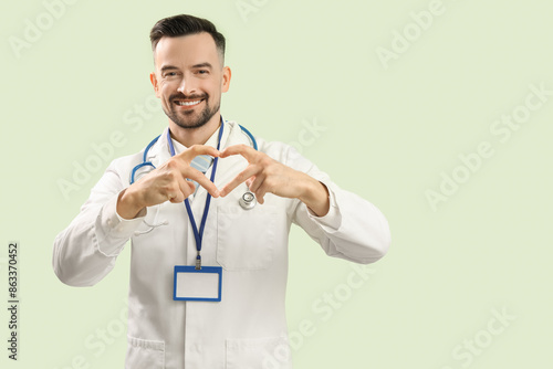 Male doctor making heart wi...
