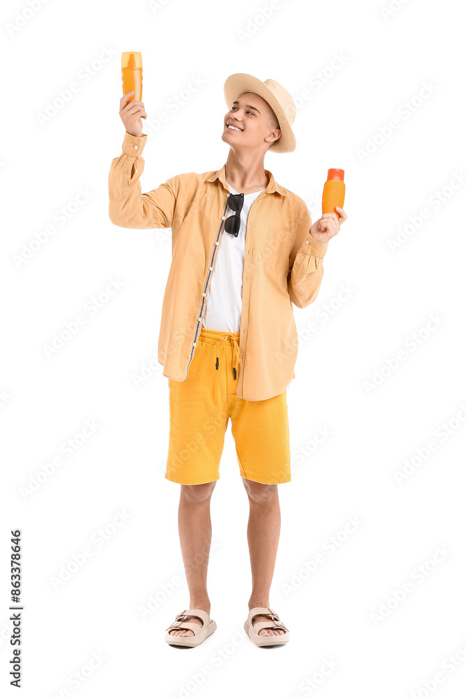 Happy young man with bottles of sunscreen cream isolated on white background Happy young man with bottles of sunscreen cream isolated on white background