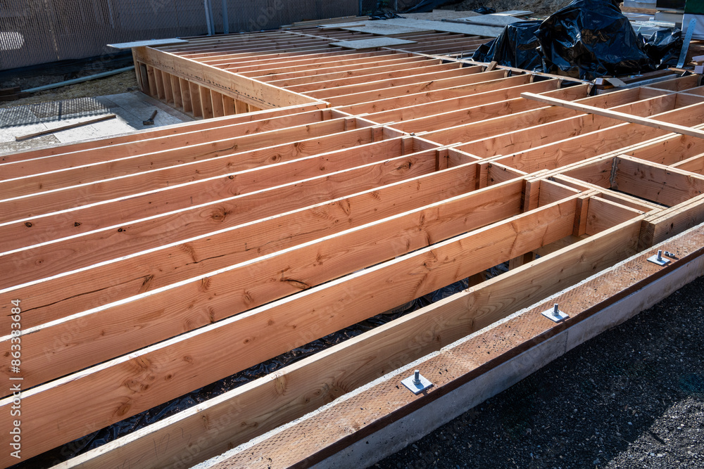 Obraz premium New home construction, subfloor built on foundation, sill plates installed with anchor bolts, floor joists in place, ready for plywood layer 